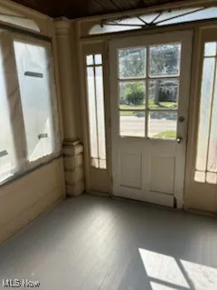 Doorway to outside with wood ceiling and wood finished floors
