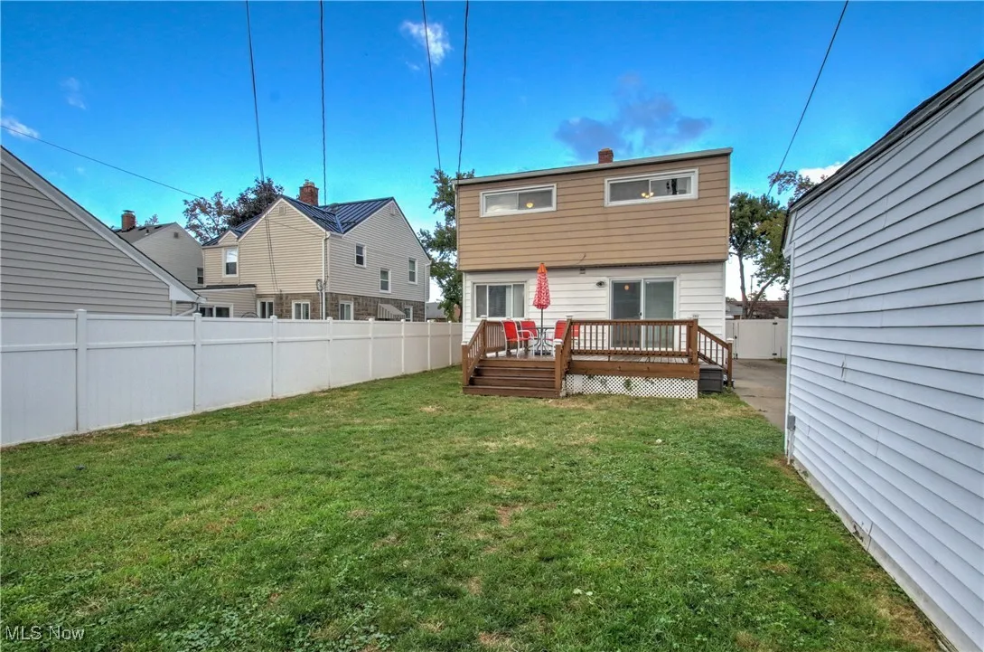 Rear view of house featuring a fenced backyard and a wooden deck