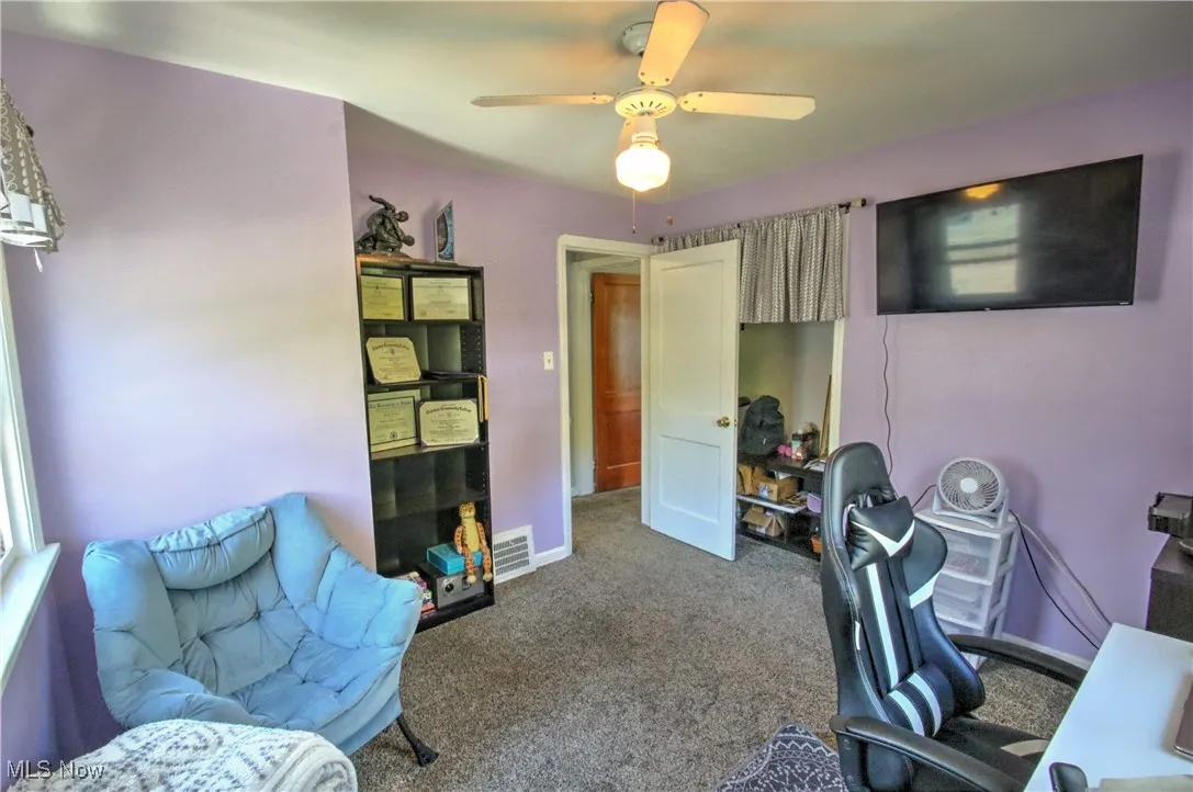 Carpeted office space with baseboards and ceiling fan