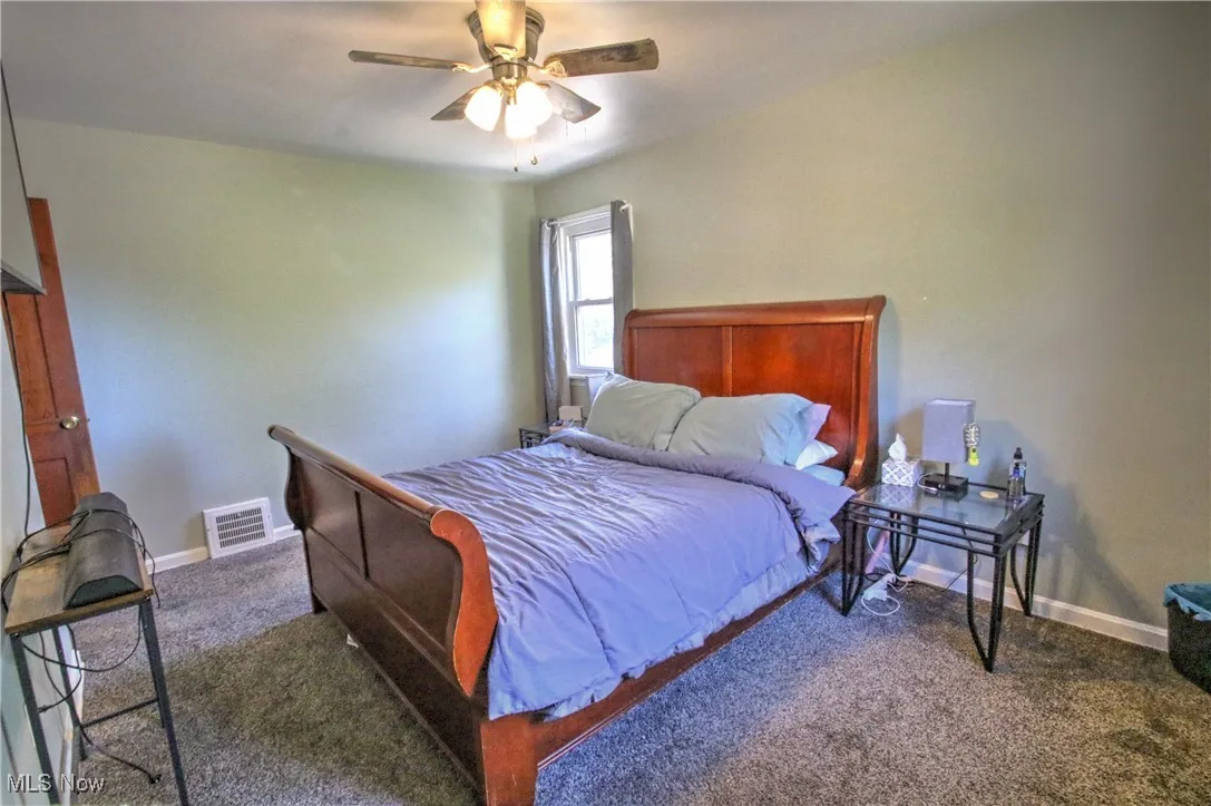 Bedroom with ceiling fan and carpet