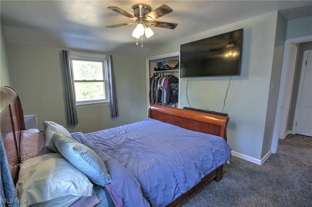 Bedroom featuring carpet, ceiling fan, and a closet