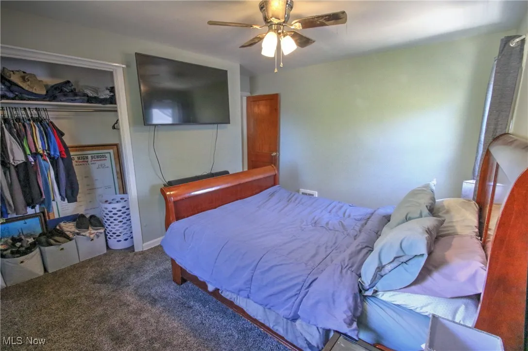 Carpeted bedroom with a closet and ceiling fan