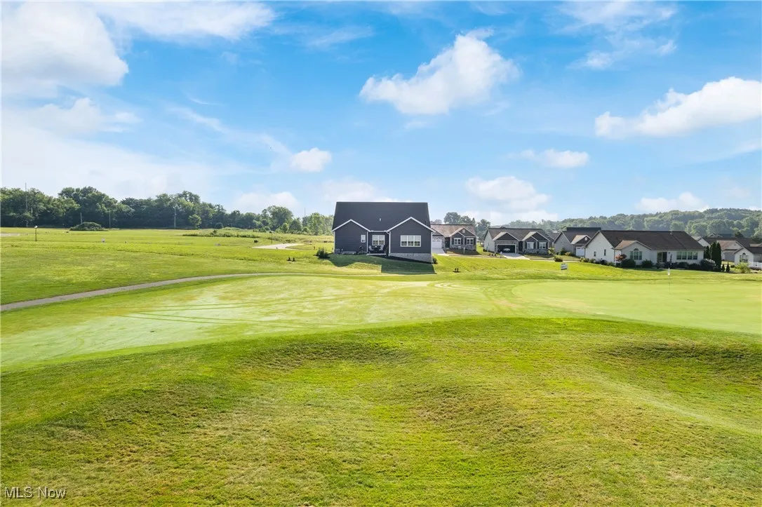 Surrounding community with golf course view, a lawn, and a residential view