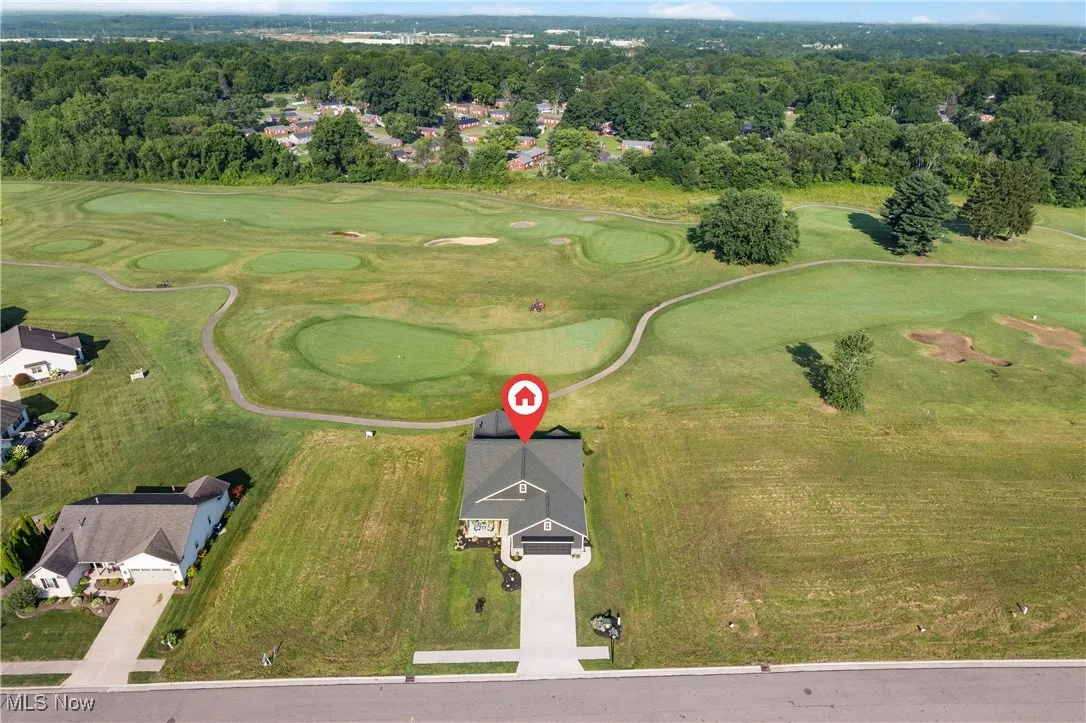 Aerial view of property's location featuring a local golf course and nearby suburban area