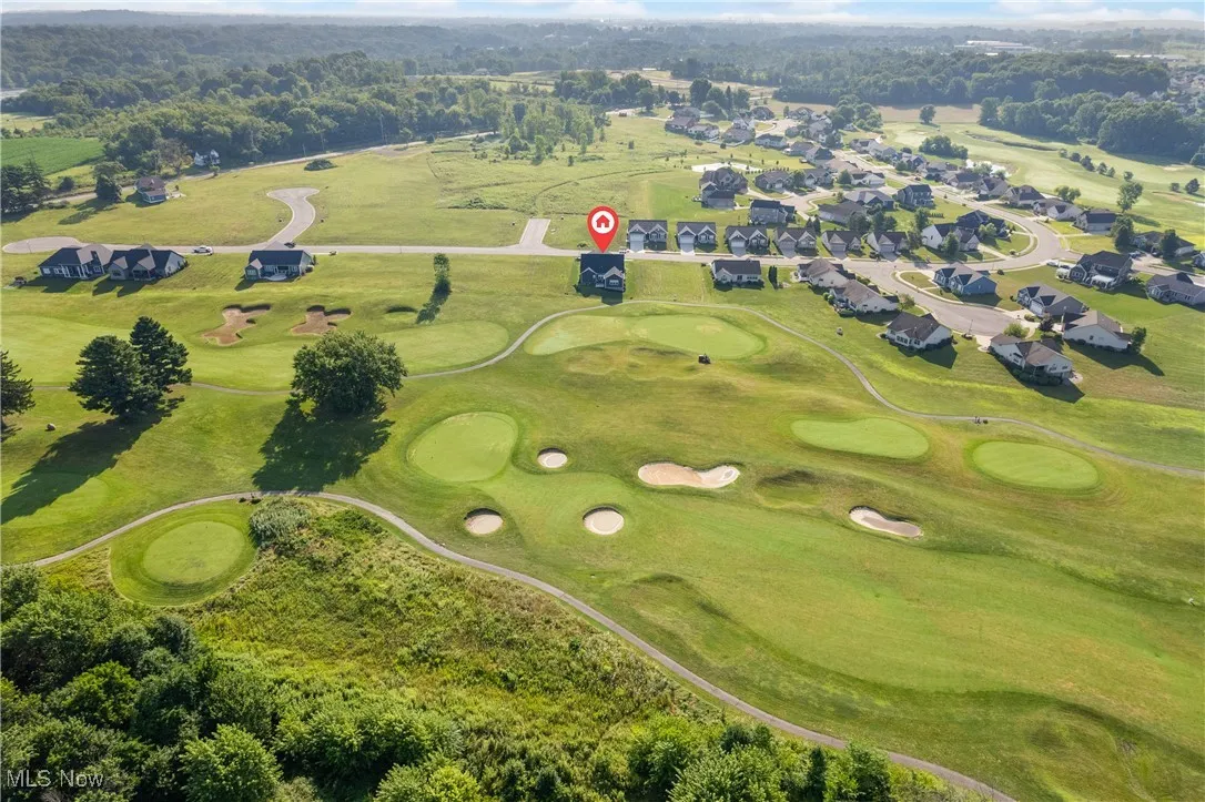 Aerial view of property's location featuring nearby suburban area and a golf course