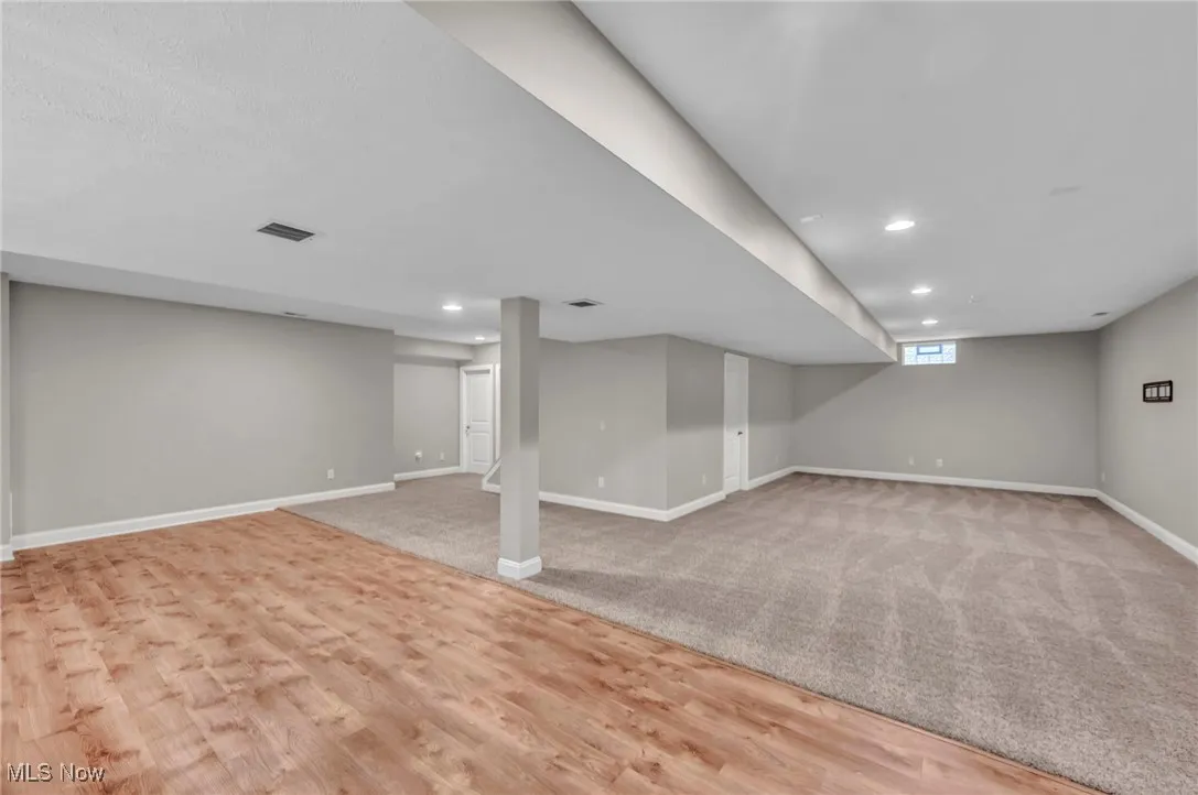 Basement featuring light wood-style flooring, recessed lighting, and light carpet