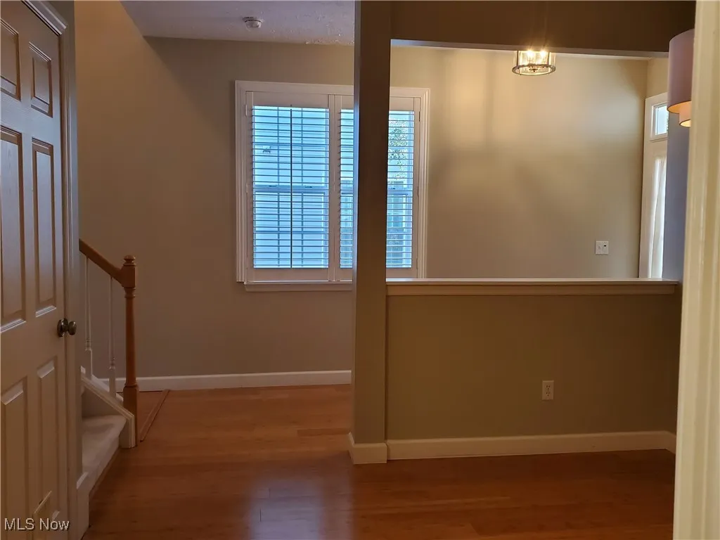 Spare room with wood finished floors and stairs
