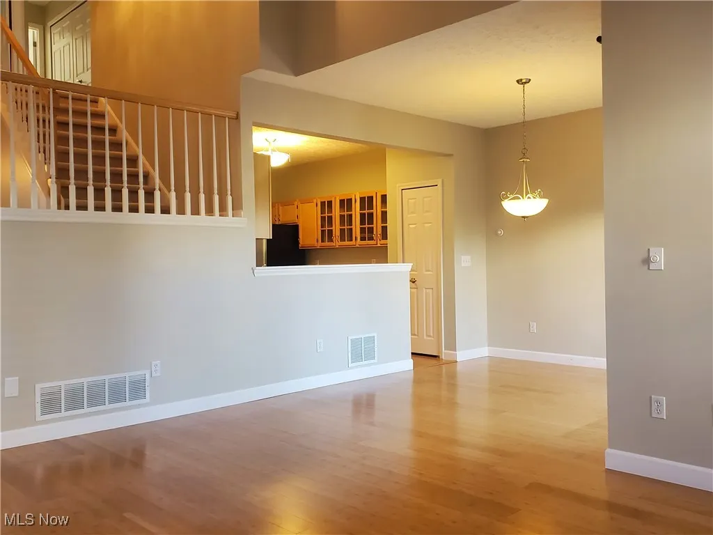 Unfurnished living room with light wood-style floors and stairway