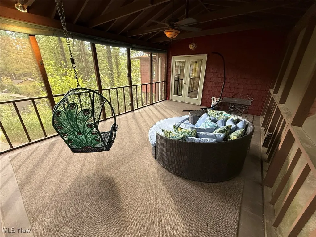Sunroom / solarium with a ceiling fan, an outdoor living space, and french doors