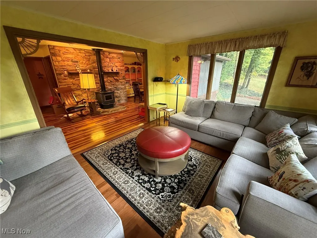 Living room featuring a wood stove and wood finished floors