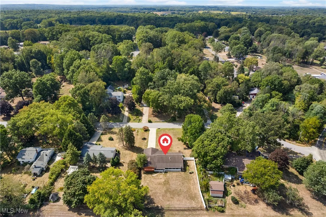 Aerial overview of property's location with a heavily wooded area