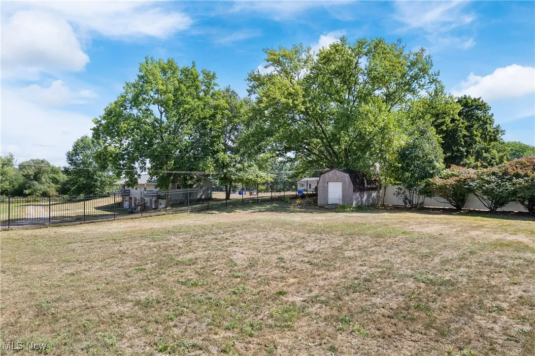 Fenced backyard featuring a storage shed