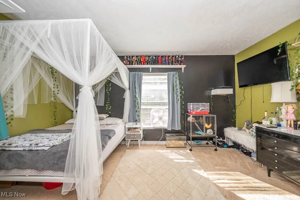 Bedroom featuring carpet and a textured ceiling