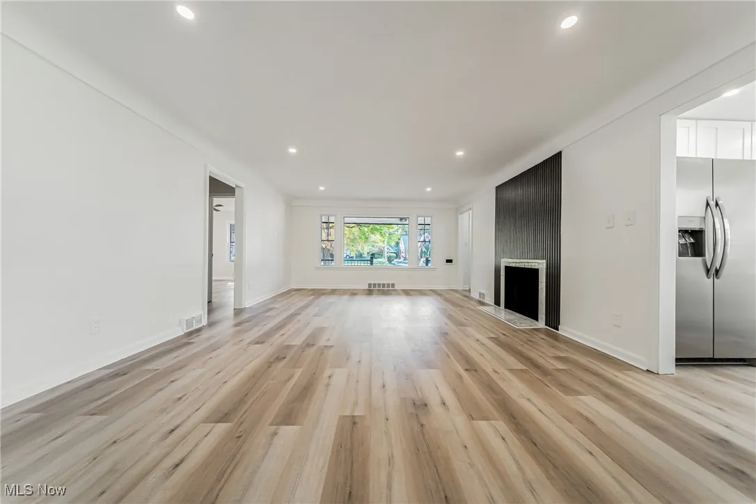 Unfurnished living room featuring recessed lighting, light wood-style floors, and a fireplace