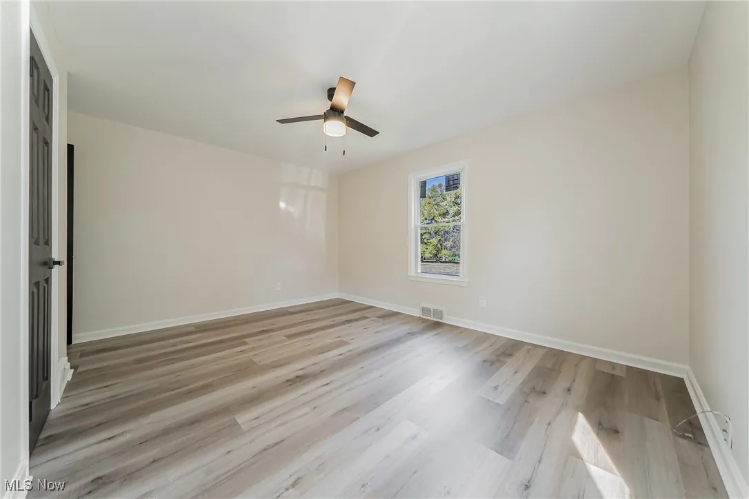 Spare room with light wood-style floors and baseboards