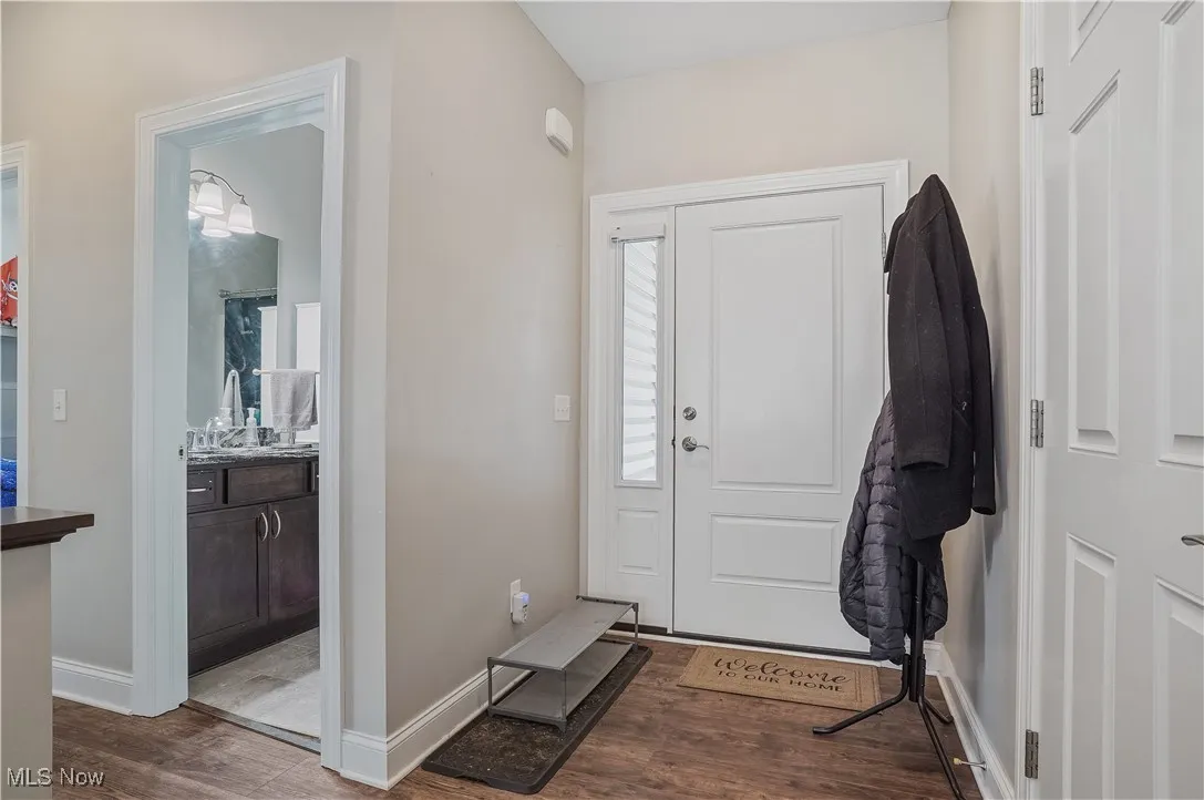 Foyer entrance with wood finished floors and baseboards