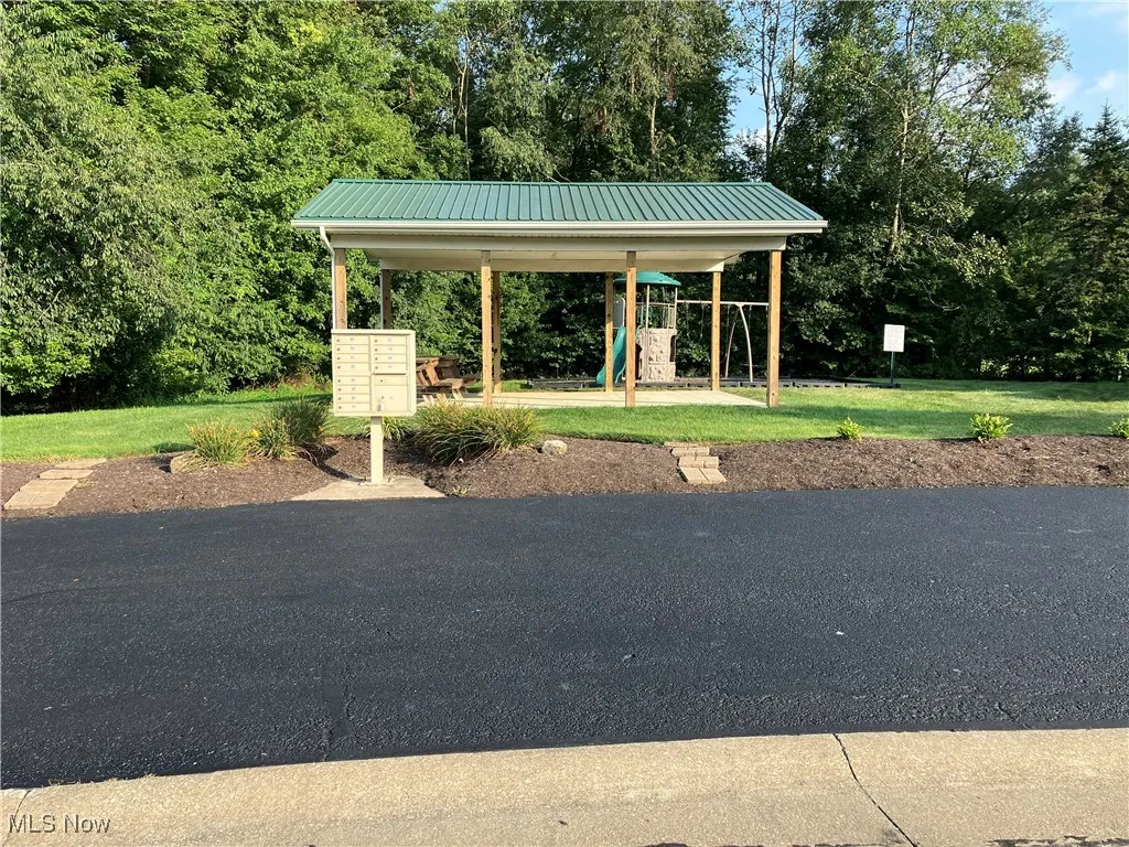 View of home's community featuring mail area and a lawn