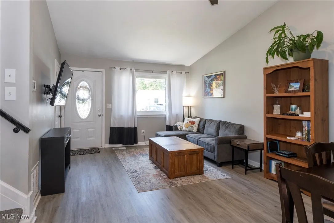 Living area with high ceiling, luxury vinyl wood look flooring and open to dining room