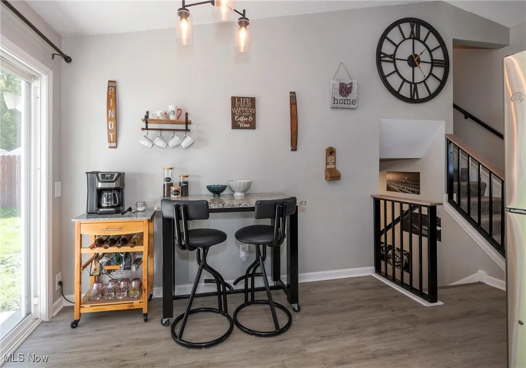 Kitchen eating area with luxury vinyl wood look flooring. Granite topped moveable island table stays.
