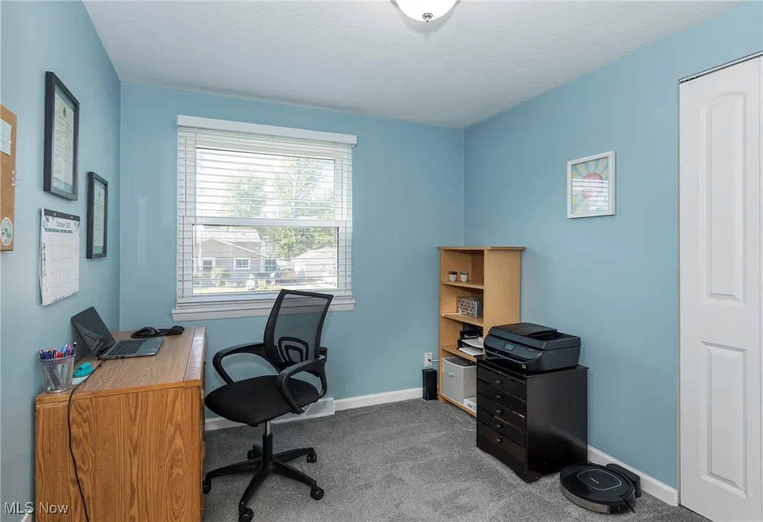 Bedroom currently used as a home office with carpeted floor
