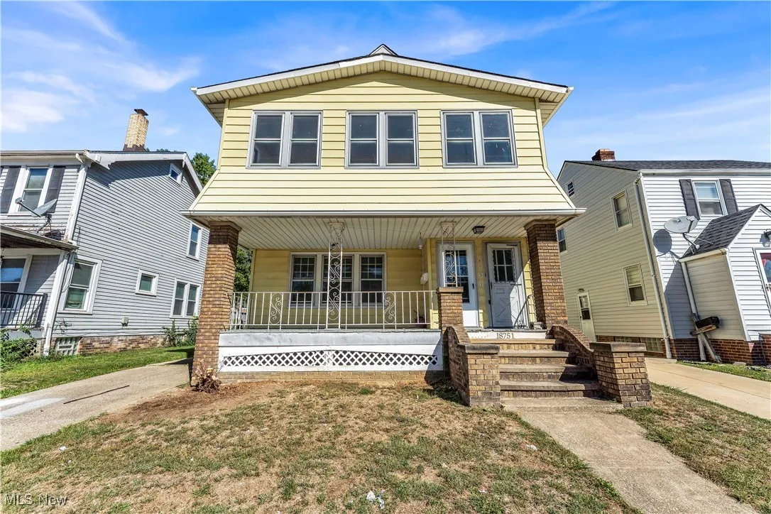View of front of property with covered porch and a front lawn