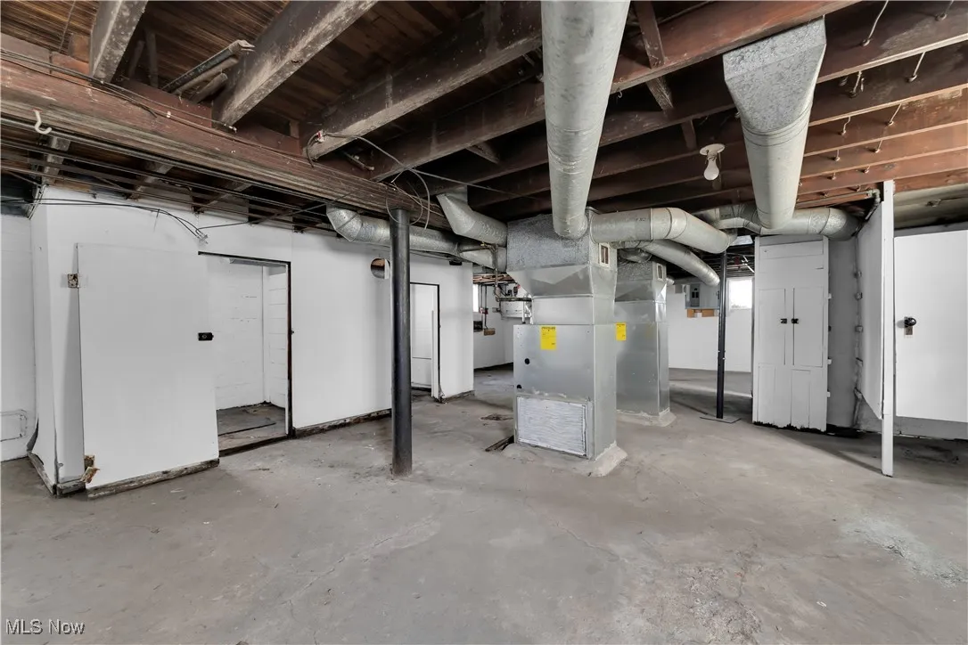 Unfinished below grade area featuring heating unit