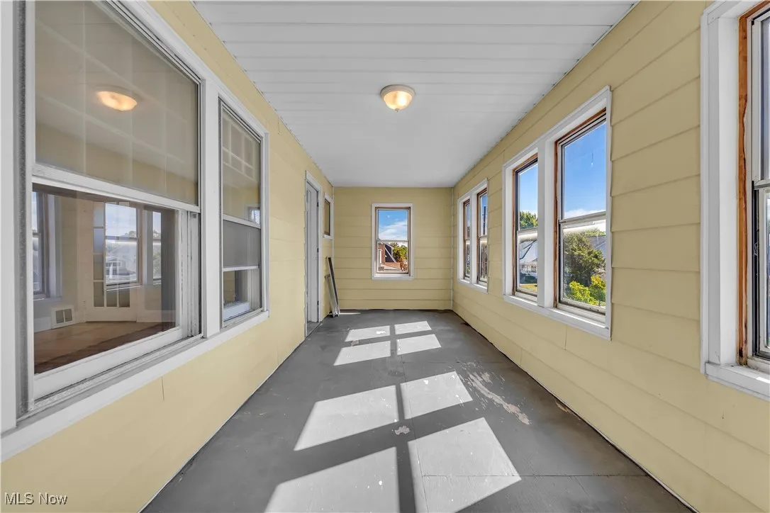 Unfurnished sunroom featuring concrete floors