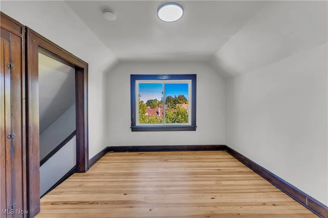 Bonus room featuring vaulted ceiling and light wood-style flooring