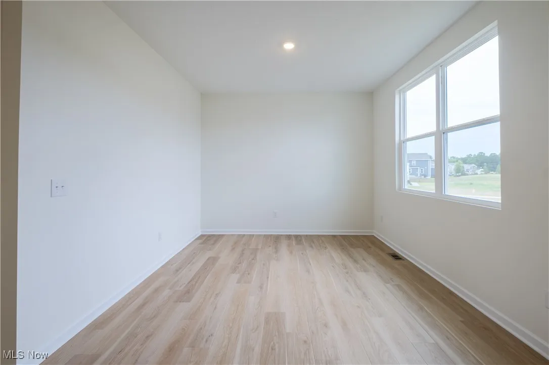 Unfurnished room with light wood-style flooring and baseboards