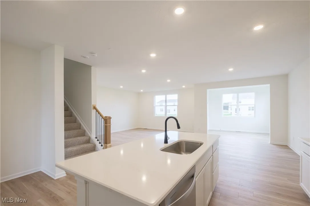 Kitchen featuring an island with sink, open floor plan, light wood finished floors, healthy amount of natural light, and recessed lighting
