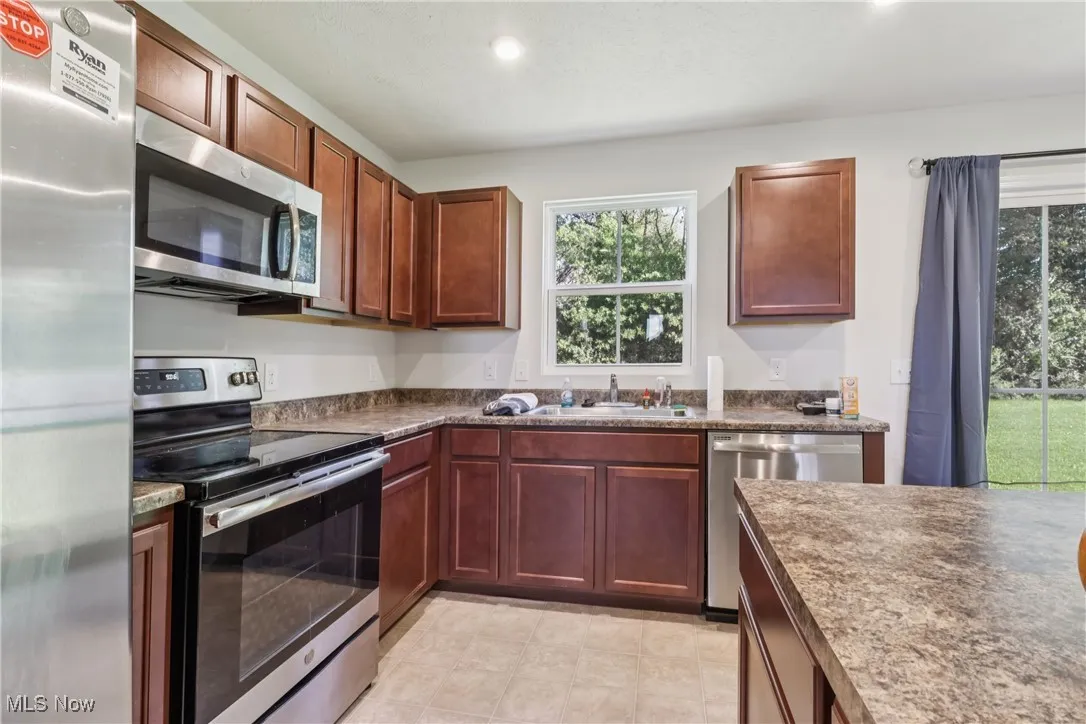 Kitchen with stainless steel appliances, dark countertops, and recessed lighting