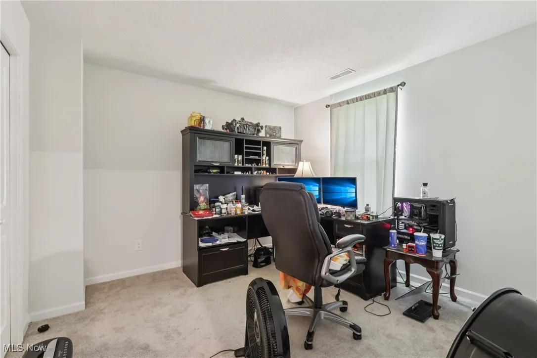 Home office featuring light carpet