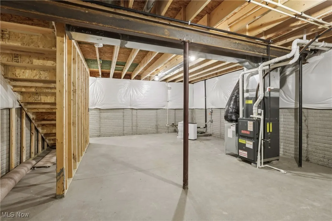 Unfinished basement featuring heating unit