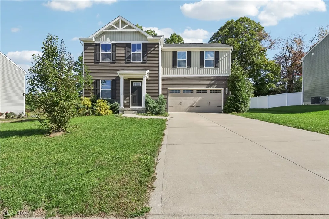 Craftsman house with concrete driveway, an attached garage, and board and batten siding