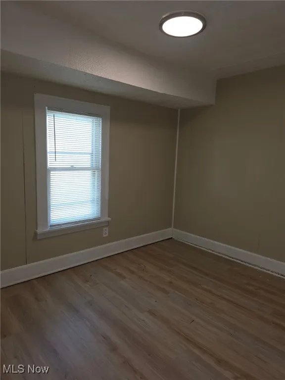 Spare room with wood finished floors and wood walls
