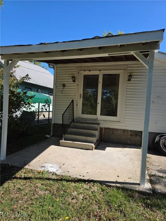 View of exterior entry with a patio area