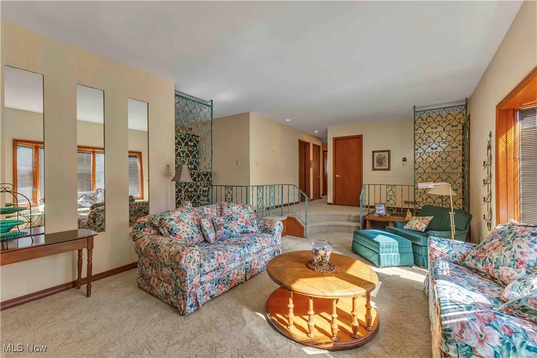 Sunken living room featuring light colored carpeting.