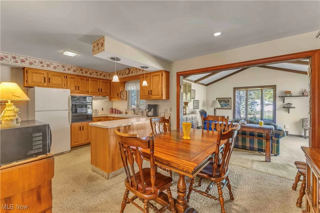 Dining area off the kitchen with light colored carpeting.