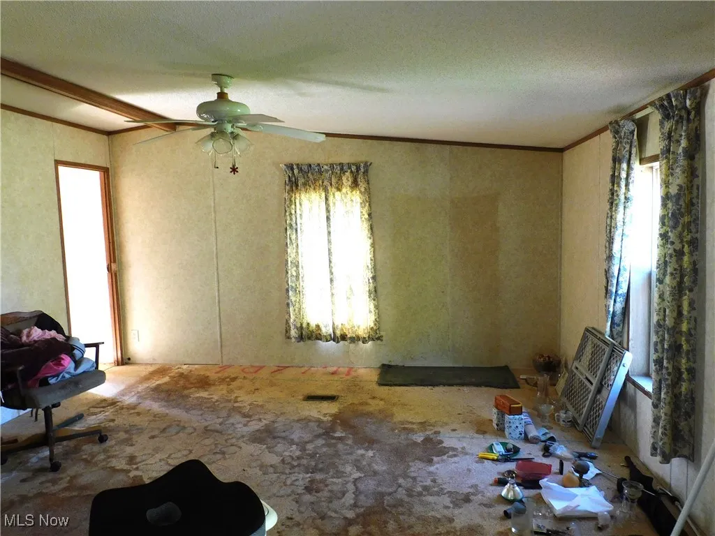 Unfurnished room with ornamental molding and a textured ceiling