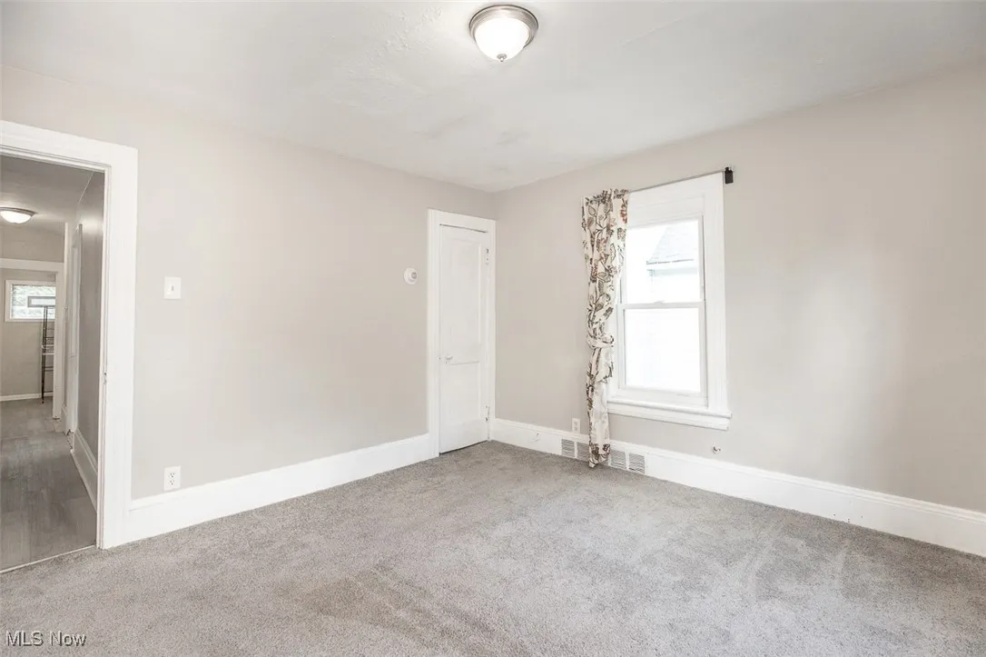 Carpeted empty room featuring baseboards