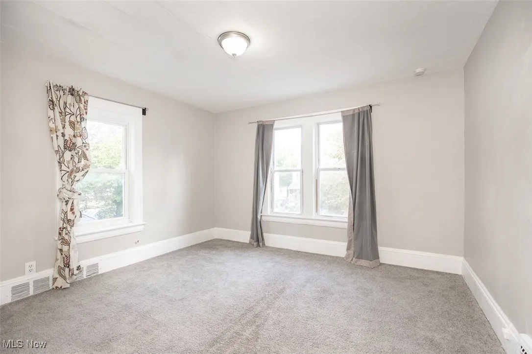 Empty room with plenty of natural light and light colored carpet