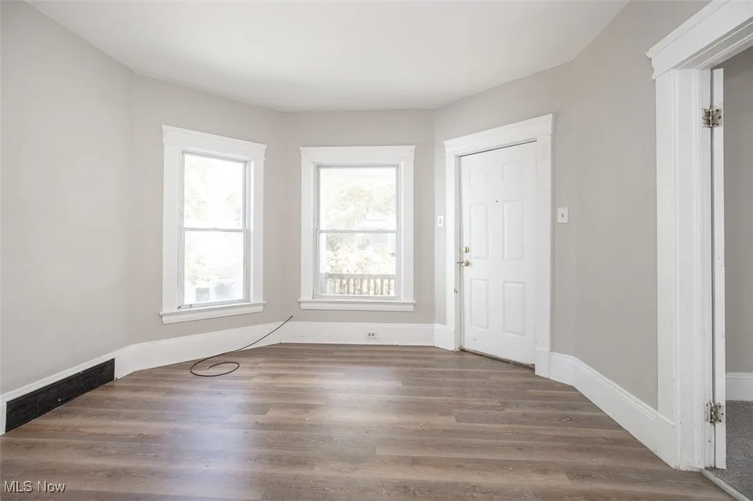 Foyer entrance featuring dark wood finished floors and baseboards