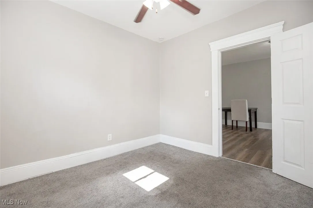 Unfurnished room with carpet floors and a ceiling fan