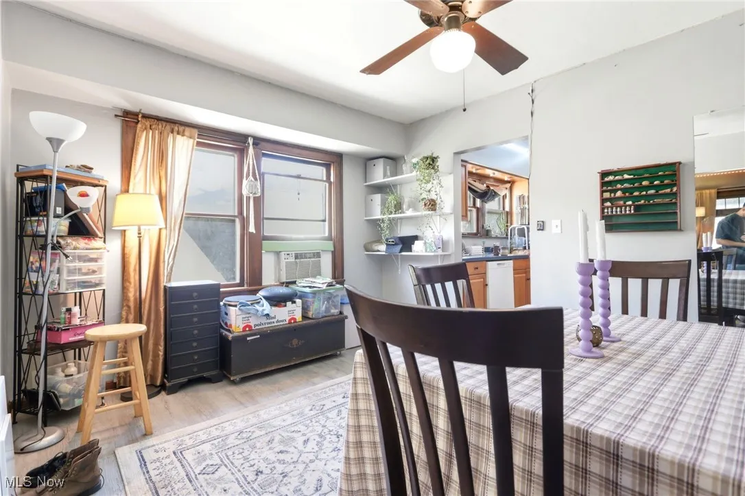 Dining room with light wood-style floors, a ceiling fan, and cooling unit
