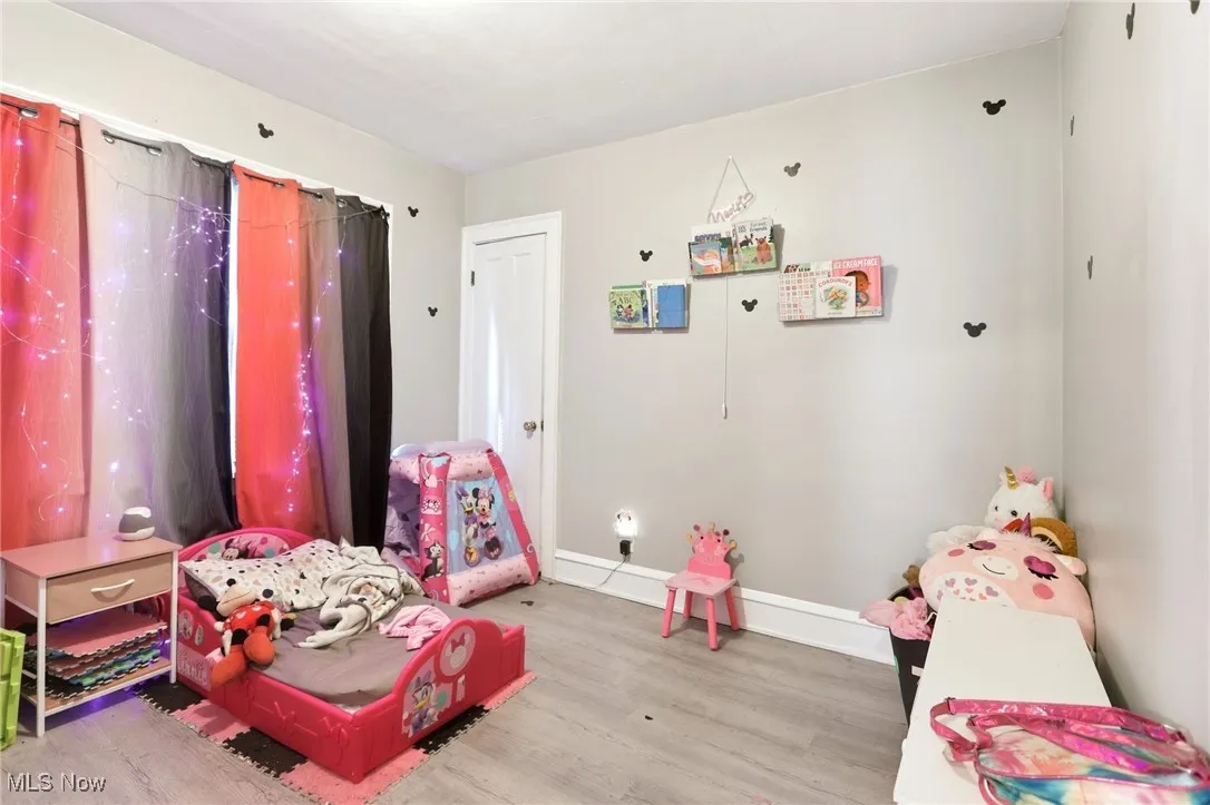Recreation room with baseboards and light wood-style floors
