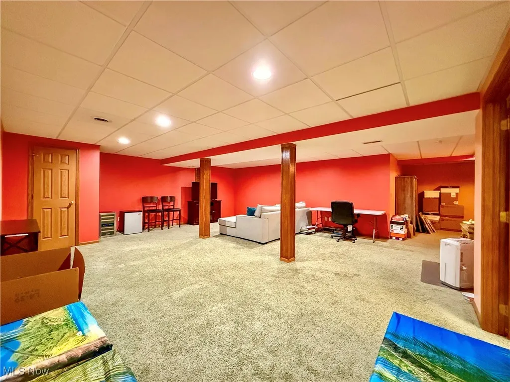 Spacious rec room featuring a paneled ceiling, carpet flooring, and recessed lighting