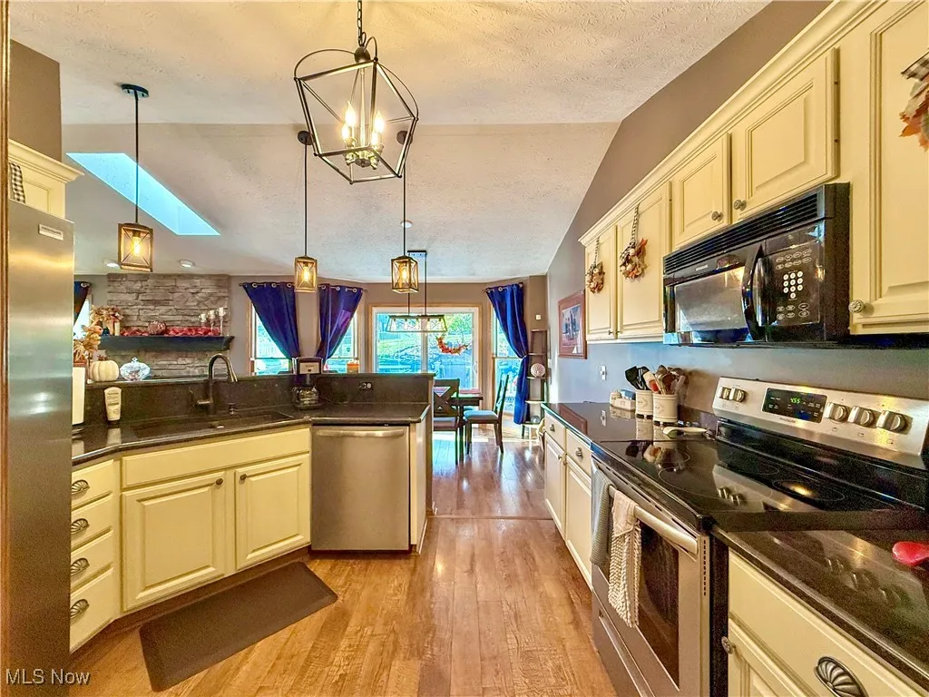 White kitchen cabinets, black mounted microwave