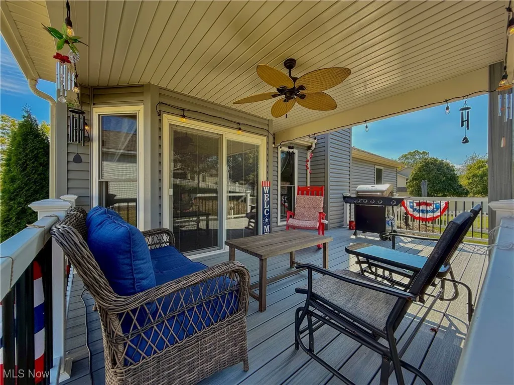 Composite covered deck with ceiling fan, area for grilling, and outdoor dining space