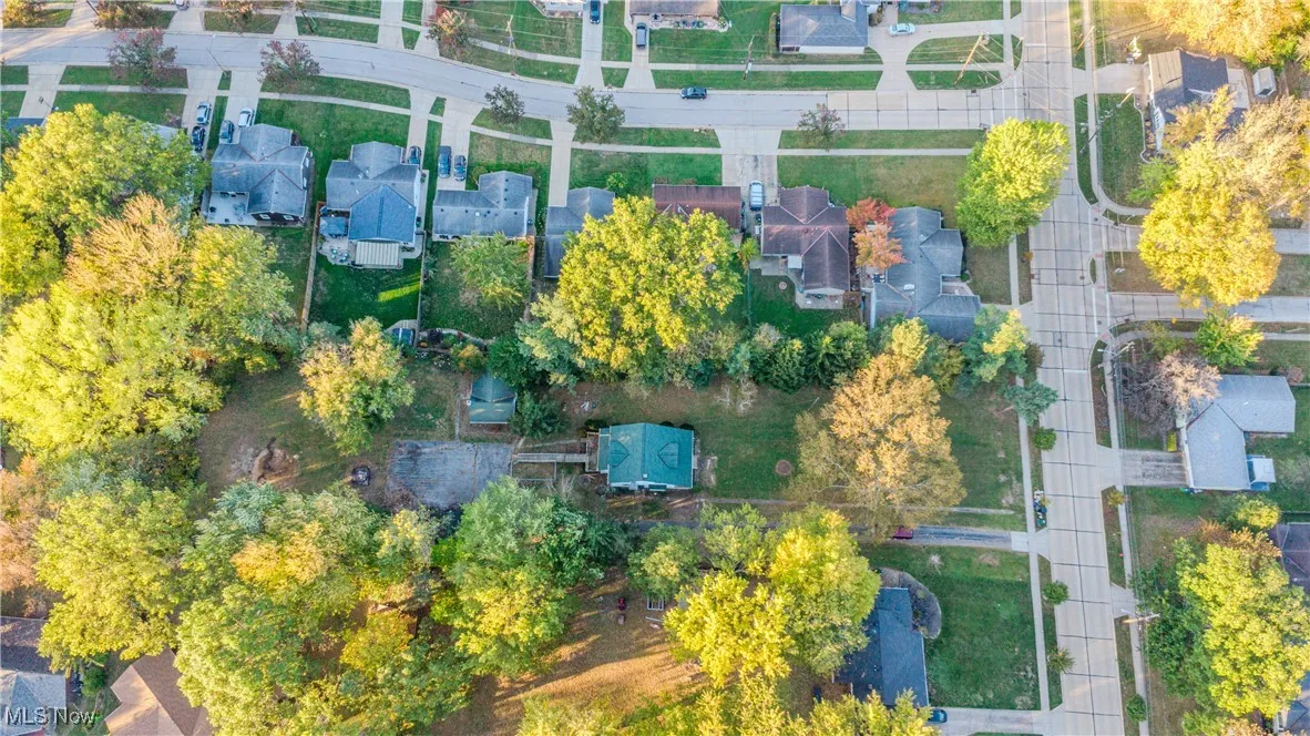 Aerial view of property and surrounding area with nearby suburban area