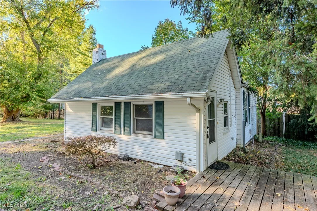 View of front of property with a shingled roof and a chimney